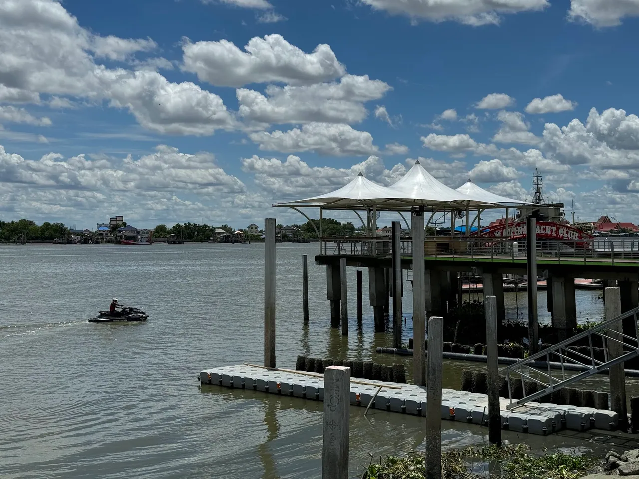 เจ็ตสกีในแม่น้ำและท่าเรือหลังคาสีขาวที่ท่าจีนมารีน่า